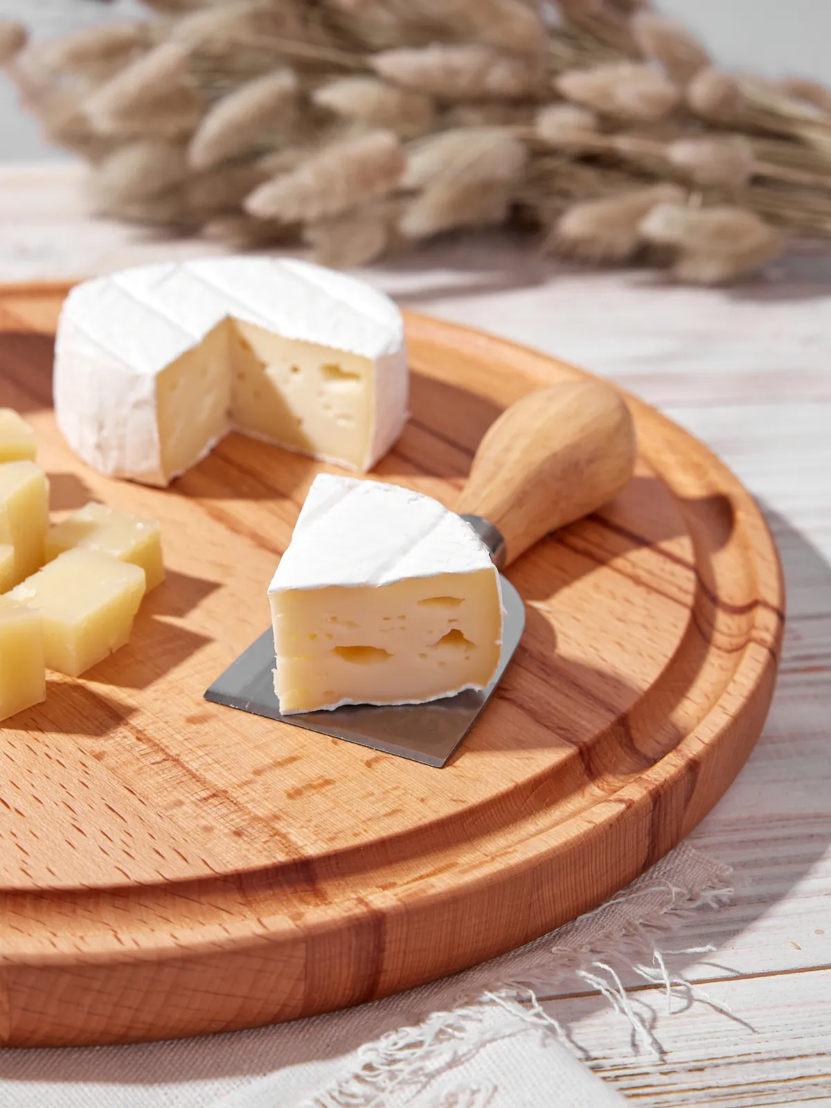 Сыр бри и колосья на деревянной доске